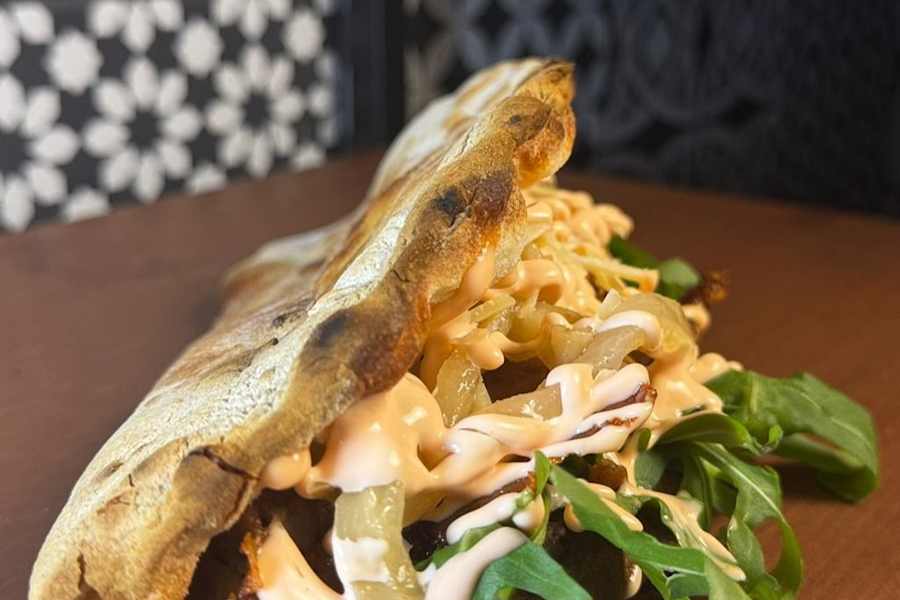 Primo piano del Porcherotto Porcoblue: porchetta, gorgonzola al cucchiaio e cipolla rossa